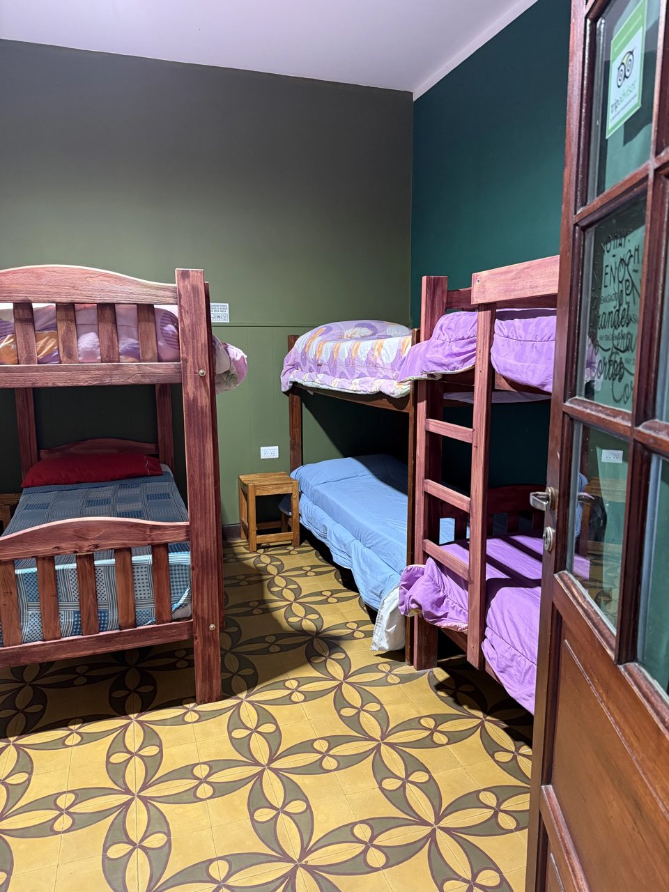 Dormitorio compartido con cuchetas de madera y piso de mosaico
