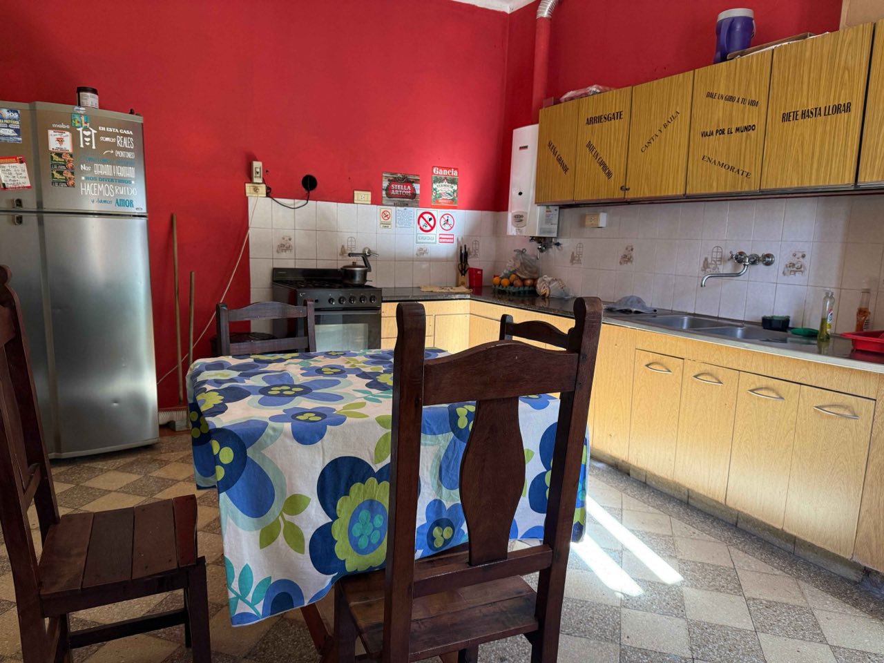 Cocina equipada con heladera, cocina a gas y mesa para comer