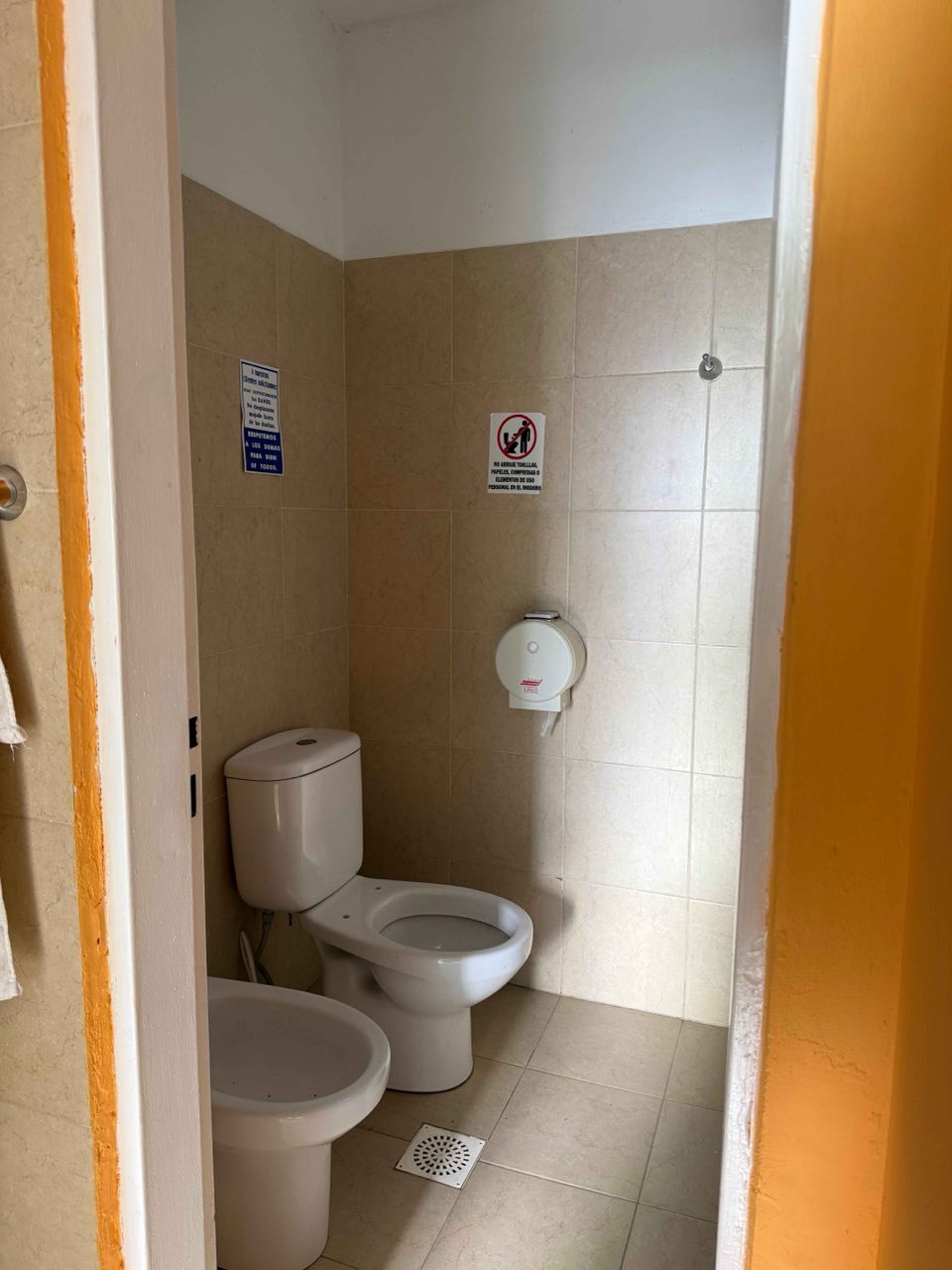Baño con inodoro, bidet y azulejos claros