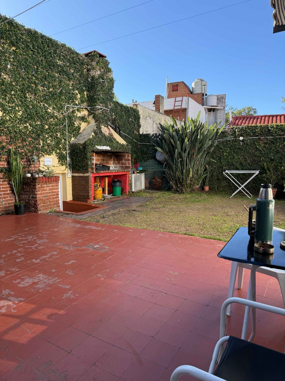 Patio amplio con asador de ladrillo, jardín y espacio para sentarse