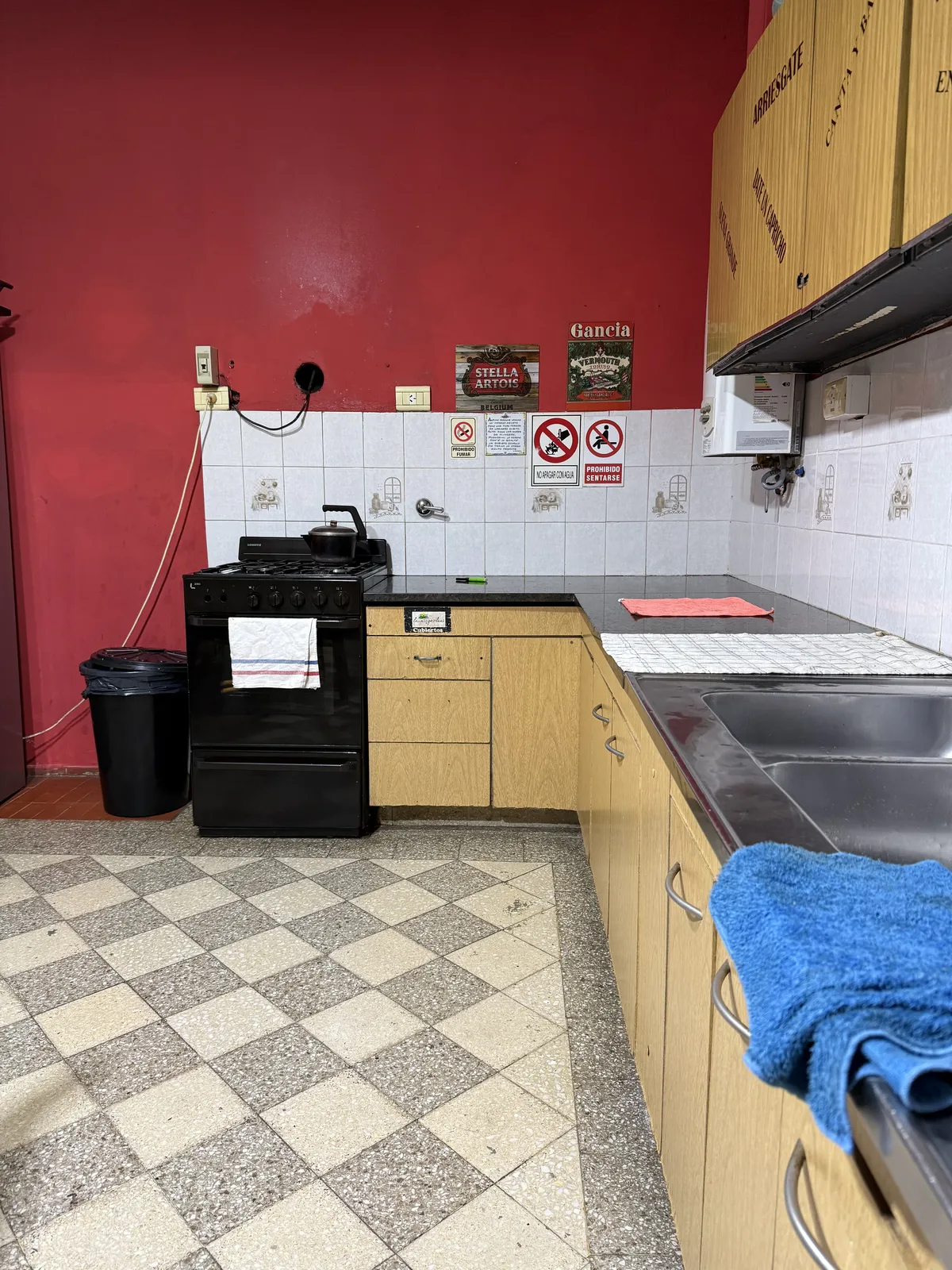 Cocina con mesada, bacha doble y cocina a gas sobre piso de damero