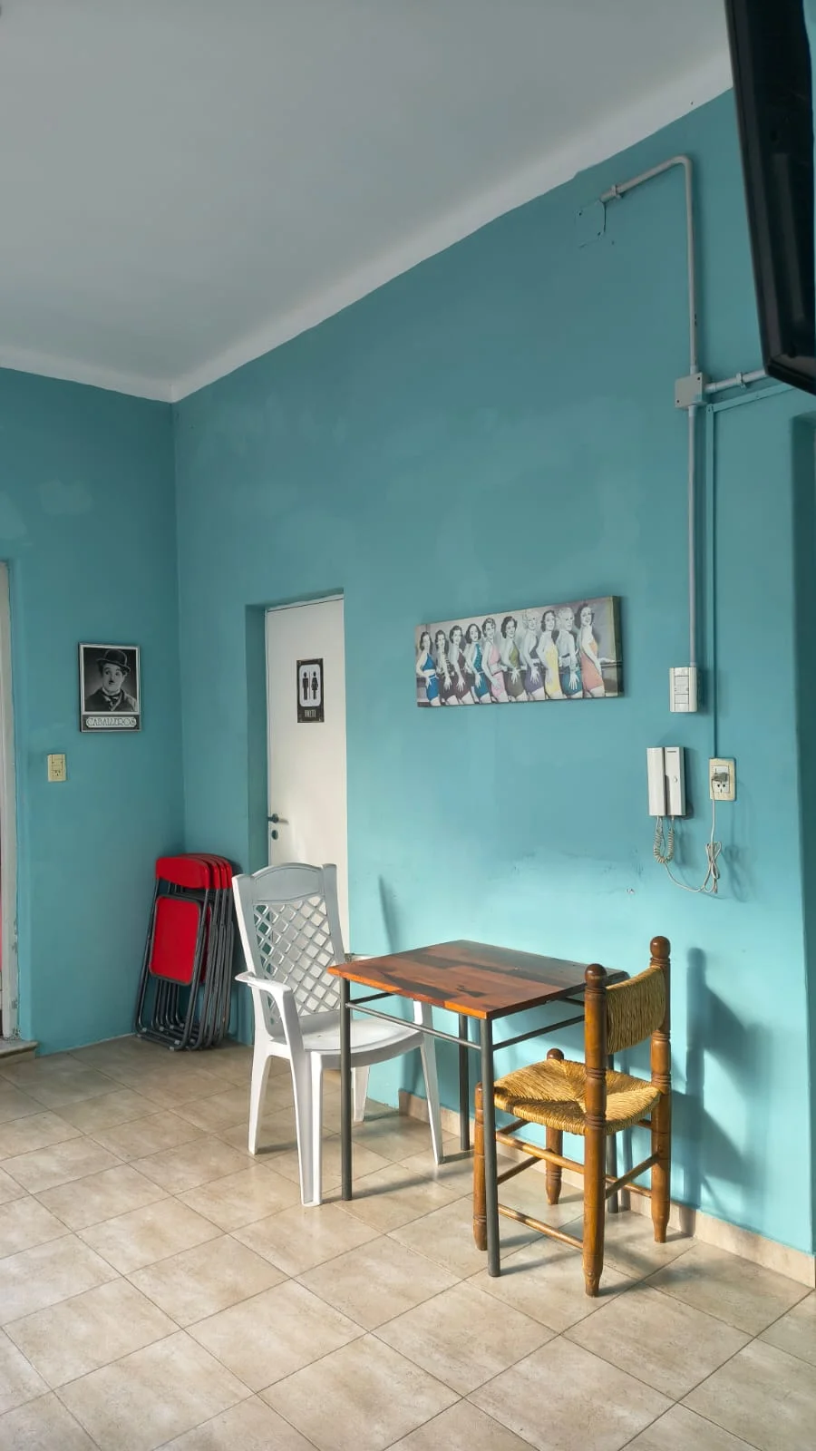 Comedor con paredes celestes, mesa y ventilación