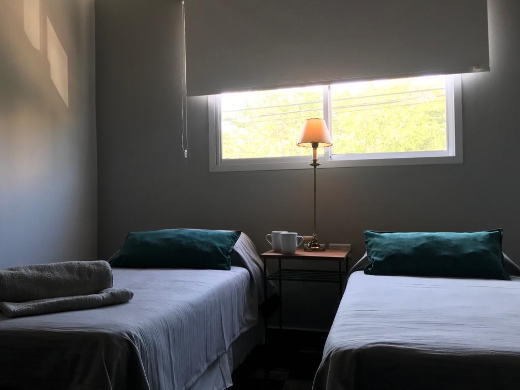 Dormitorio del dúplex con dos camas individuales, toallas y luz natural desde la ventana