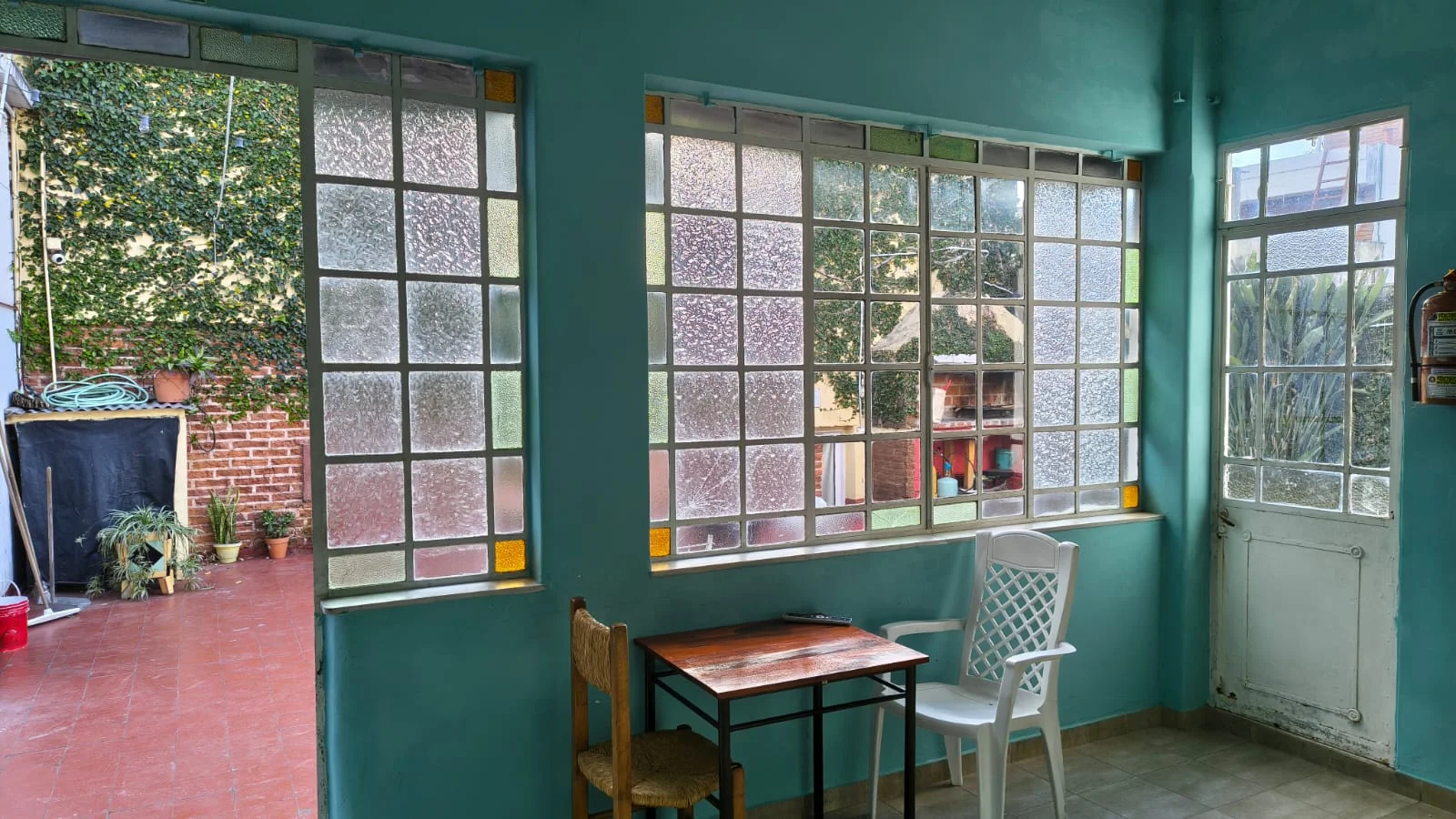 Galería interior de la casa antigua, con ventanales de vitraux y luz natural