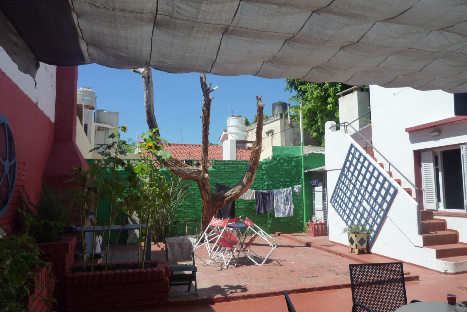 Patio con media sombra, plantas y mesas para sentarse